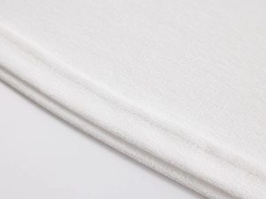 Close-up of premium white knit fabric showing double-needle stitching and texture detail
