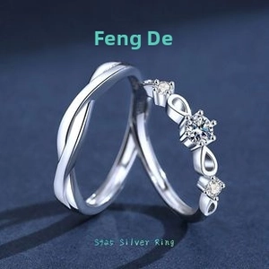 Detail of S925 sterling silver infinity couple rings with white zircon inlay on blue surface