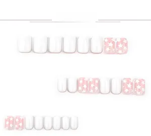 Detailed view of short square press-on nails with white finish and pink star patterns