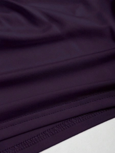 Close-up of deep purple knitted fabric with high-quality stitching and smooth texture