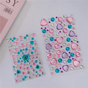 Flat lay of colorful heart and round acrylic gem stickers in pink, blue, and purple tones