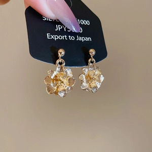 Macro shot of silver flower earrings showing detailed layers and 1000 silver hallmark