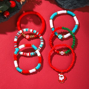 Christmas polymer clay beaded bracelet set with festive charms on a red background
