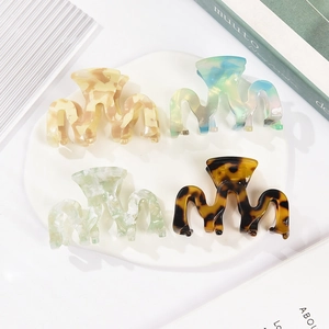 Set of 4 acetate hair claws with marble and tortoiseshell patterns in a wavy design