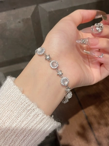 Close-up of a silver floral bracelet with chalcedony and zircons on a woman wrist