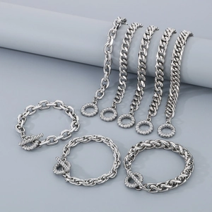 Detailed close-up of various silver cuban link chains with crystal toggle clasps