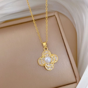 Detail of clover pendant with central pearl and zircon accents in a jewelry box