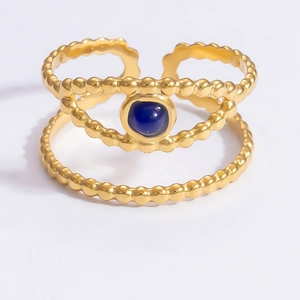 Close-up of dual-layer golden ring featuring a round deep blue gemstone setting