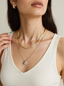 Layered gold snake chain and teardrop gemstone pendant necklace set on model