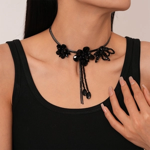 Close-up of black floral choker necklace with long bead tassels on female neck