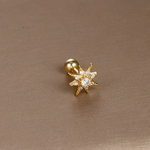 Macro shot of gold star cartilage piercing stud with round zircon and screw back