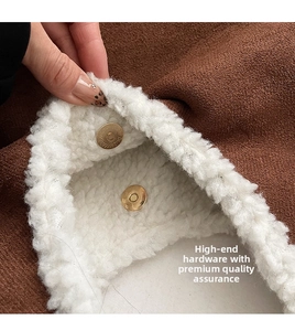 Detail of brown suede tote bag with white fleece lining and golden magnetic metal buckles