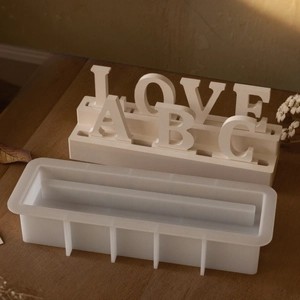 Détail du moule en silicone avec présentoir de lettres en résine sur table en bois
