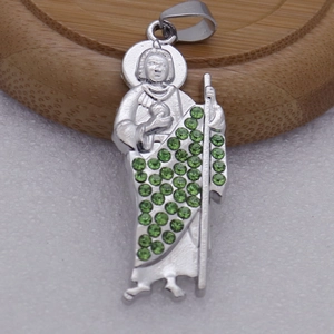 Détail macro d'un pendentif religieux en argent serti de micro-pavé de zircons verts