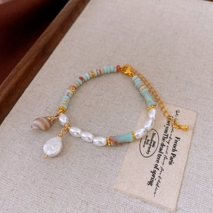 Detail of freshwater pearl necklace with shoushan stone shell pendant on linen background