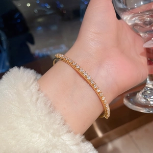 Detail of 18K gold plated tennis bangle with sparkling cubic zirconia on female wrist