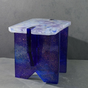 Artistic resin stool detail featuring purple petals and deep blue glitter legs