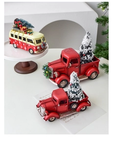 Close-up of vintage metal red pickup truck and bus with miniature Christmas trees and gifts