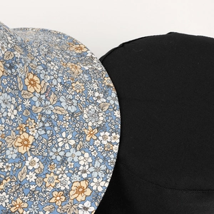 Detail of floral printed reversible bucket hat fabric and solid black cotton texture