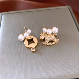 Detail of 18K gold-plated asymmetrical earrings with pearl and rocking horse pendant