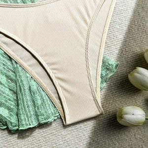 Detailed close-up of ribbed fabric and floral lace embroidery on women's swimwear