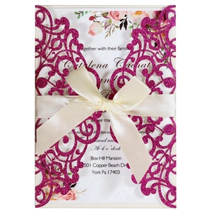 Elegant laser-cut purple glitter wedding invitation with a cream satin ribbon bow