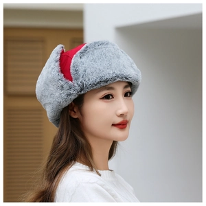Detail of winter trapper hat showing thick grey faux fur lining and red windproof fabric