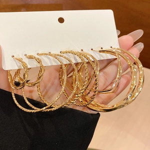 Detail view of 6 pairs of gold hoop earrings set with twisted and polished textures