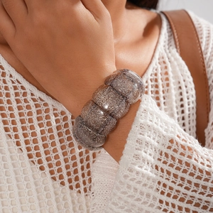 Detail of glitter brown acrylic irregular geometric elastic bracelet on a female wrist