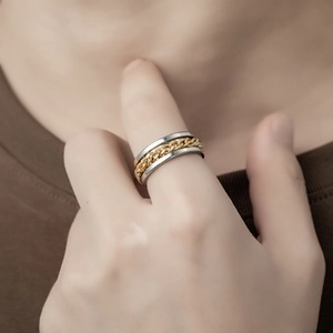 Detailed view of dual-tone industrial ring with gold cuban chain inlay on silver band