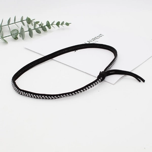 Detail of black and white woven hat band with tassels for DIY accessory styling