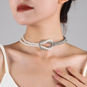 Close-up of pearl and silver bead knotted necklace worn on a fashion model's neck