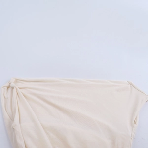 Detailed view of white pleated fabric texture with buttons on one-shoulder dress