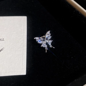 Macro shot of silver zircon butterfly tassel ear cuff on black velvet jewelry box