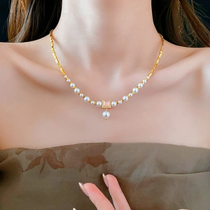 Detail of 18k gold plated necklace with pink square gemstone and white pearls on neck