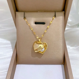 Elegant gold heart pendant necklace with shimmering crystals and a center white pearl