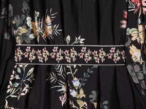 Détail rapproché de la robe fleurie avec ceinture à la taille et motifs colorés