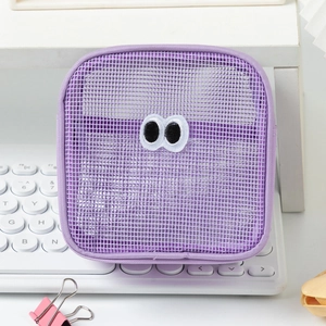Close-up of purple mesh pouch with cartoon eyes detail on a white keyboard
