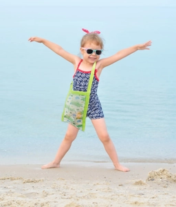 Green mesh beach bag for kids featuring cartoon crocodile prints with sand toys inside