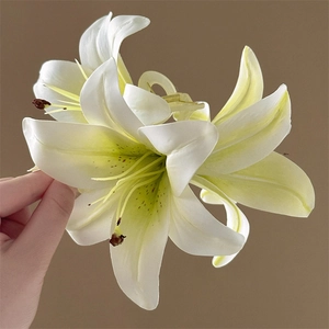 Detailed view of elegant white lily hair claw clip with yellow center and spring mechanism
