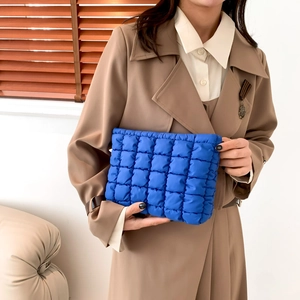 Blaue gesteppte Clutch im Bubble-Design für Damen präsentiert in einer Lifestyle-Umgebung
