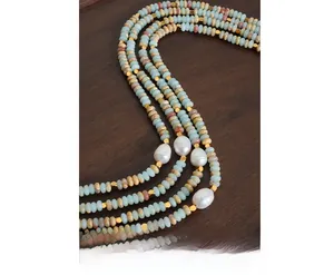 Detailed close-up of multi-layer beaded necklace with baroque pearls and blue stones
