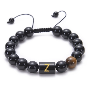 Macro detail of adjustable obsidian bead bracelet featuring a gold letter Z on tiger eye stone