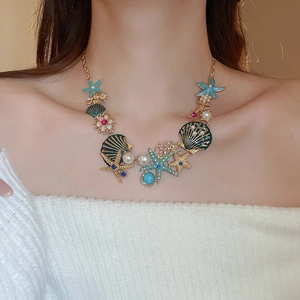 Detailed shot of starfish and shell pendant necklace with pearls on a female model