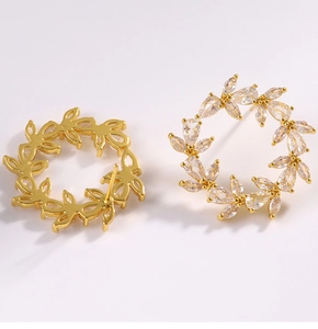 Macro shot of gold-plated C-shaped earrings featuring drop-cut cubic zirconia crystals