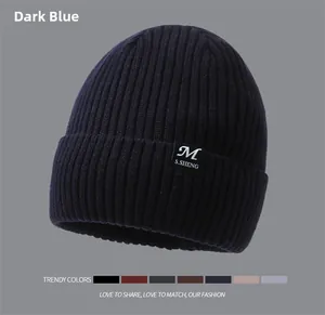 Detailed close-up of dark blue ribbed knit beanie with stylish letter patch embroidery