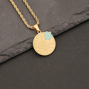 Detail of gold Tughra coin pendant with blue flower accents on a twisted rope chain