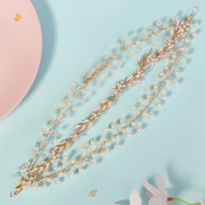 Macro detail of gold bridal headband with layered pearls, crystals, and metallic leaves