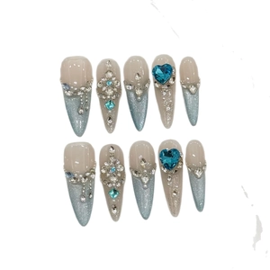 Blue cat eye press-on nails with stiletto shape, rhinestones, and blue heart gemstone