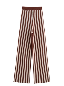 Dettaglio dei pantaloni larghi in maglia a righe marroni e bianche con vita alta e texture
